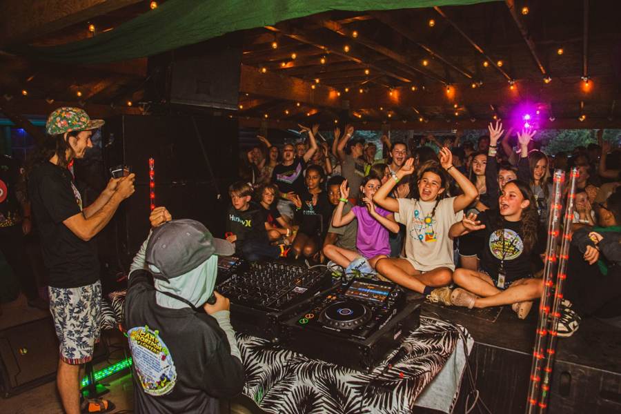 Campers cheering as a DJ performs at the end-of-week show