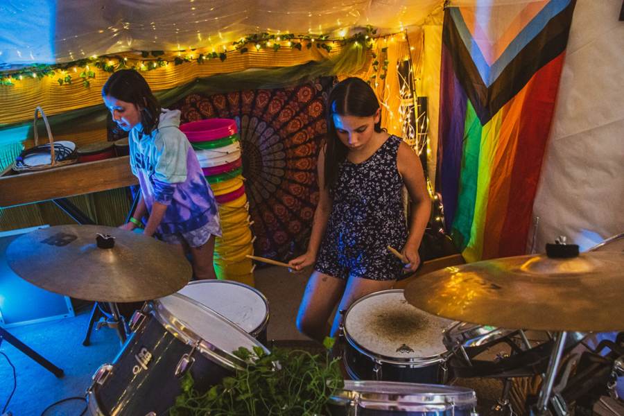Two campers playing drums together