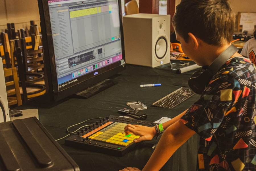 A camper playing a glowing launch pad next to a studio monitor