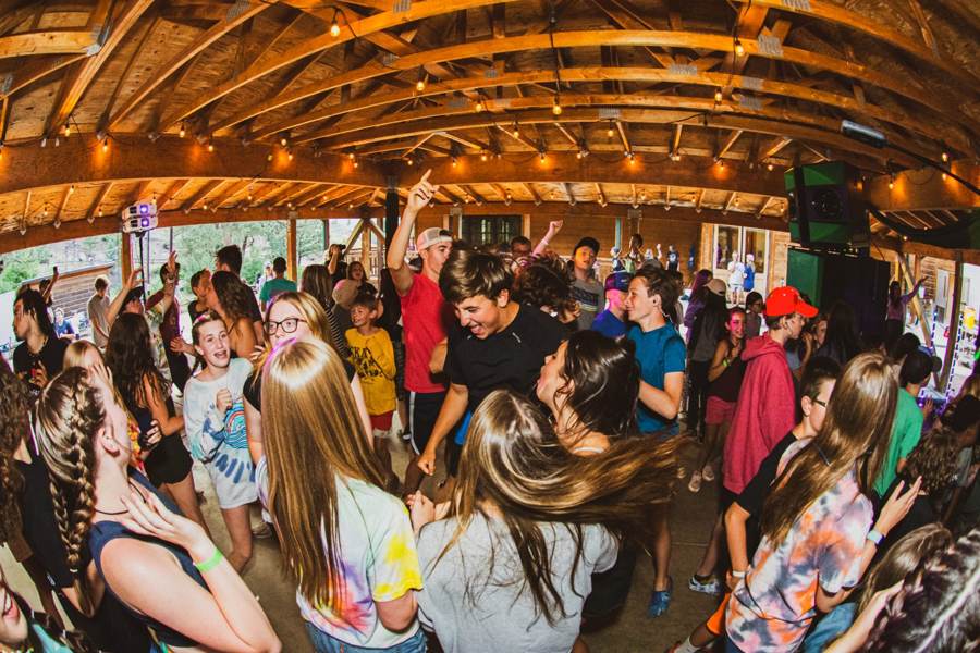 Campers dancing at the end-of-week show under string lights